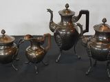 three silver teapots and a tea pot on a table