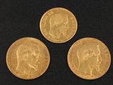 three gold sovereigns, one of which has a head of a woman and one of which is a man