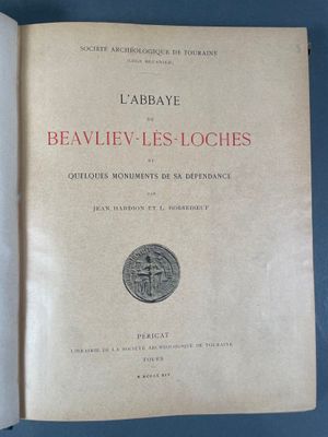 un livre ouvert posé sur une table, avec une pièce dessus