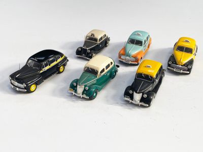 plusieurs petites voitures sont alignées sur une surface blanche