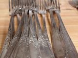a lot of spoons and forks sitting on a table
