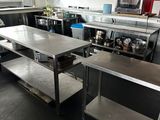 une grande cuisine équipée de plans de travail et d'étagères en acier inoxydable
