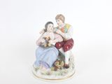 une figurine représentant un homme et une femme assis sur un banc