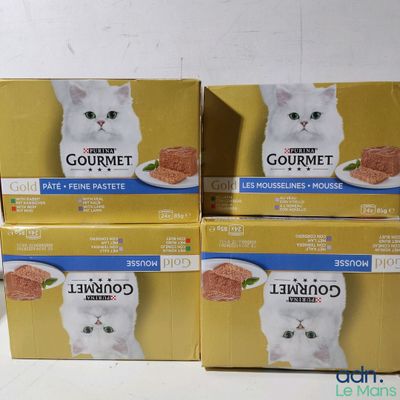 trois boîtes de nourriture pour chat posées sur une table blanche