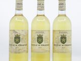 trois bouteilles de vin blanc posées l'une à côté de l'autre sur une surface blanche