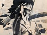 an old photo of a native american man in a feather headdress