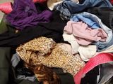 a pile of clothes in a suitcase on the floor