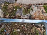 a pair of scissors sitting on the ground next to a stone wall