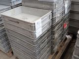 de nombreuses piles de récipients en plastique empilés sur une palette