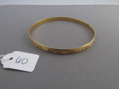 un bracelet en or avec une étiquette de prix posé sur une table