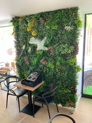 a green wall with plants growing on it in a restaurant