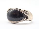 une image représentant une bague avec une pierre noire au centre