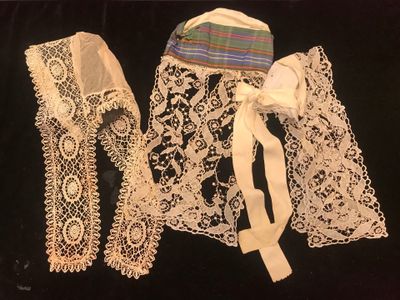 three pieces of lace are displayed on a black surface