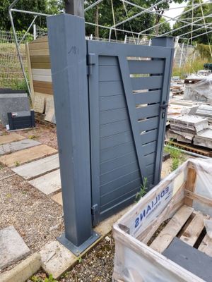 une caisse en bois posée à côté d'un portail métallique