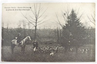 une photo en noir et blanc représentant un homme à cheval à côté d'un groupe de chiens