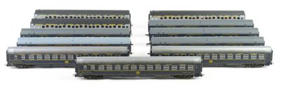 several model trains are lined up in a row on a white surface