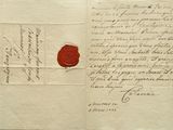 une vieille lettre portant un cachet de cire, posée sur une feuille de papier
