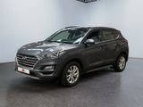 un SUV gris garé dans un showroom, avec une horloge accrochée au mur