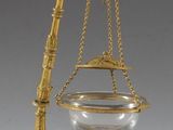 une image représentant une balance en or sur laquelle est posé un bol en verre