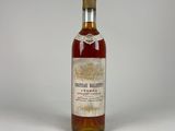 an old bottle of whiskey sitting on top of a white table