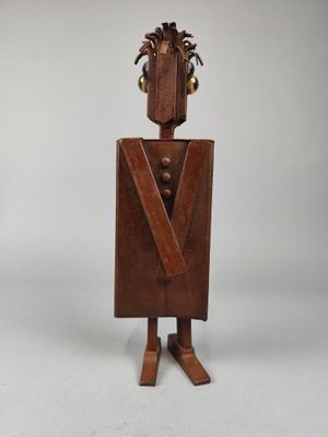 une vieille sculpture en bois représentant un homme en smoking