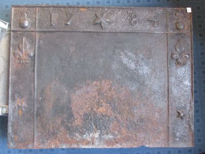 Plaque de cheminée en fonte de fer datée 1784, la bordure or…