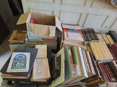 une pile de livres posée par terre à côté d'une autre pile de livres