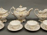 a group of white and gold tea and coffee cups and saucers