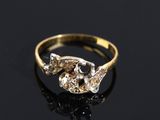 a close up of a gold ring with two diamonds on a black surface