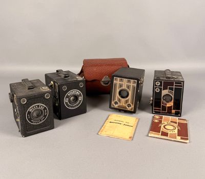 Plusieurs vieux appareils photo sont posés sur une table à côté d'un étui