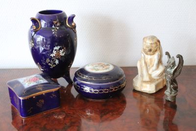 a table with a vase, a box, and a figurine on it