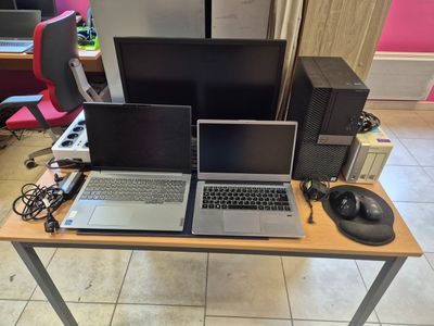 deux ordinateurs portables posés sur une table, avec un clavier et une souris