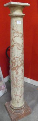 a marble pedestal in front of a red wall