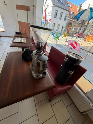 une table sur laquelle est posée une cafetière, devant une fenêtre