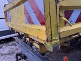 a yellow dump truck with a red and white stripe on the back