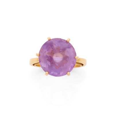 une bague en or jaune sertie d'une pierre violette