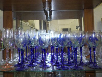 many wine glasses on a glass shelf in a room