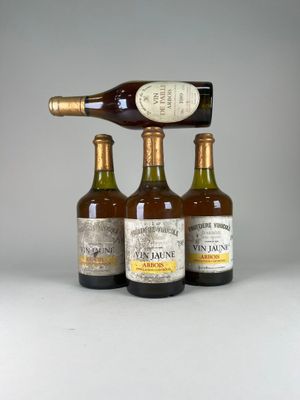 trois bouteilles de vin empilées les unes sur les autres à côté d'une bouteille de vin