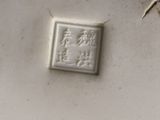 a close up of a white vase with a stamp on it