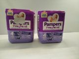 two boxes of baby diapers sitting on top of a table