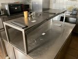 stainless steel counter top in a commercial kitchen with a microwave in the background