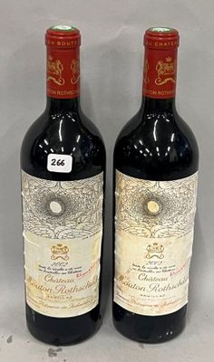 two bottles of red wine sitting next to each other on a table