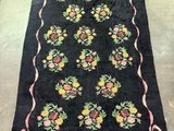 a black rug with a floral design on it on the floor