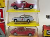 three toy cars in a display case on a table