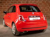 the small red car is parked in front of a brick wall