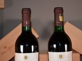 two bottles of wine sitting next to each other on a table