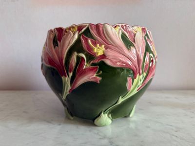 un vase vert orné de fleurs roses, posé sur une table