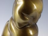statue of a cat sitting on its back on a white surface