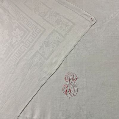un gros plan sur une nappe blanche ornée d'un monogramme rouge