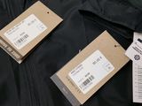 two black jackets with tags on them sitting next to each other